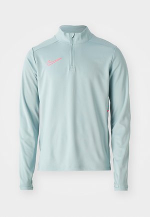 Helleblaue langärmelige Pullover mit Halbreißverschlusskragen und pinkem Nike-Logo auf der Brust. Glattes Material mit leichtem Stretch.