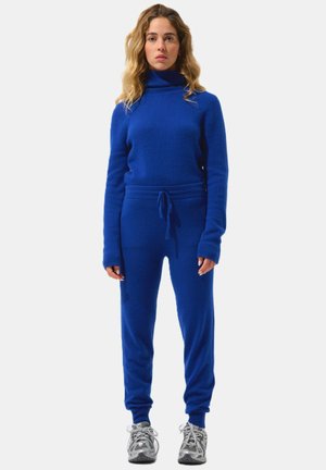 Blaues Strickpullover- und Jogginganzug-Set mit hohem Kragen, langen Ärmeln und Kordelzugbund. Mit gerippten Bündchen und weichem Material.