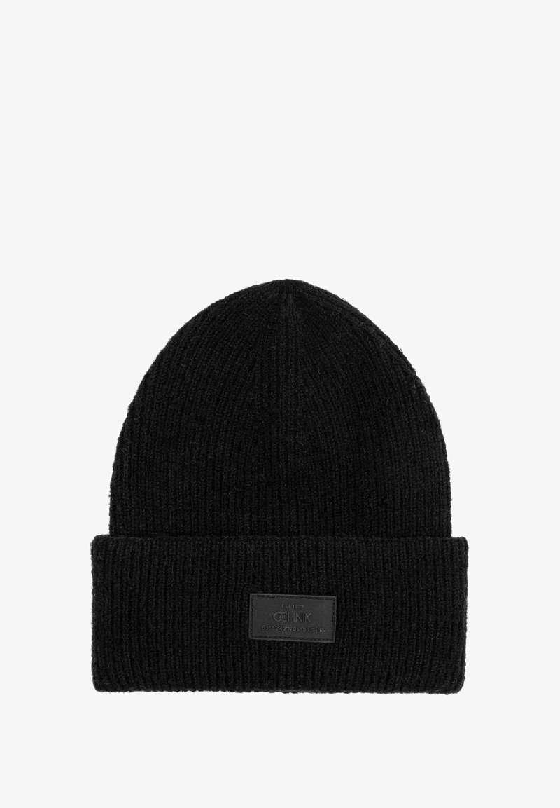 Czarna dziana czapka z prążkowaną teksturą i złożonym mankietem. Posiada prostokątną naszywkę na mankiecie. Materiał wydaje się ciepły i trwały.