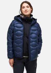 Marineblauer Steppjacke mit gewelltem, gestepptem Design, Kapuze und Reißverschluss. Verfügt über ein Logo auf der Brust und kontrastierenden Kragenbeschriftung.