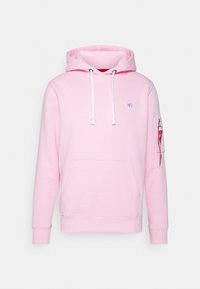 Ljusrosa hoodies med vit dragkedja, framfickor i kängurustil, litet bröstlogo och dragkedjeficka på ärmen med röd etikett.
