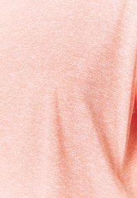 Lyse ferskenfarvet stof med et tekstureret, meleret mønster, der viser en glat, blød overflade og subtile farvevariationer.