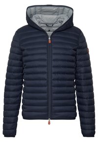 Giacca a strati blu navy con chiusura a zip, cappuccio staccabile e design trapuntato leggero. Presenta un tirazip in pelle arancione e una patch con il logo.