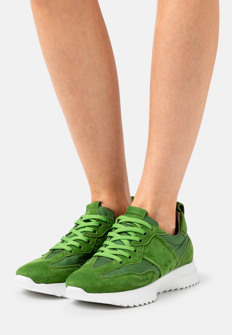 Baskets en daim vert et nylon avec des surfaces texturées, des lacets plats et une semelle en caoutchouc blanche avec un motif en zigzag.