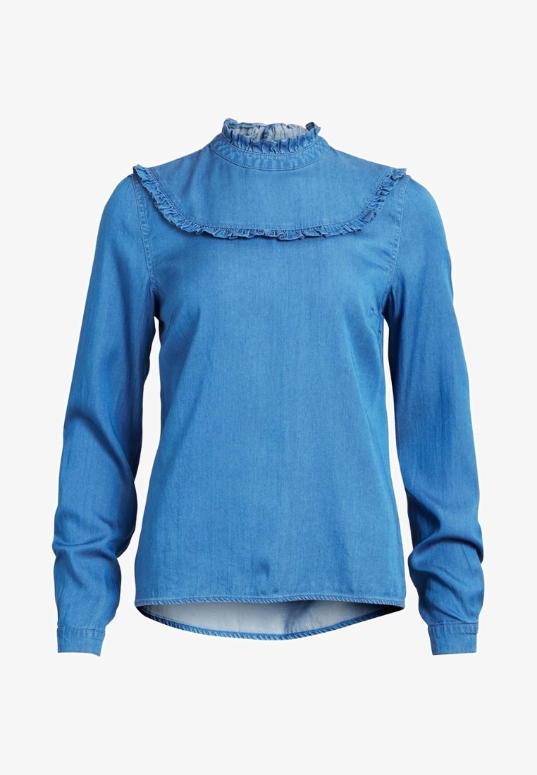 Blouse en denim bleue à manches longues avec col montant volanté et détail d'empiècement, poignets ajustés et ourlet légèrement arrondi.