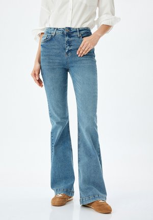 Light blue flared jeans made of denim with a smooth texture. Features high waist design, five-pocket styling, and standard front button closure.