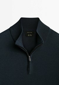 Marineblauer Strickpullover mit Reißverschlusskragen. Verfügt über einen strukturierten Stoff und ein dezentes Logoetikett im Kragen.