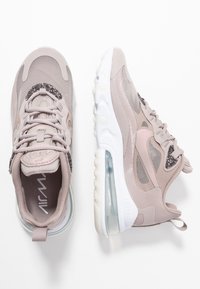Light pink sports shoes with suede and mesh materials, featuring a textured pattern, translucent air sole, and decorative accents.