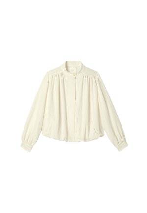 Blouse à manches longues couleur crème avec épaules froncées, col rond, fermeture boutonnée devant et poches sur les coutures latérales.