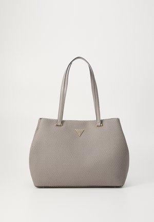 Beige tekstureret shopper-taske med to skulderstropper og et lille trekantet metal Guess-logo foran i midten.