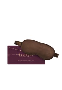 Mascherina da sonnno in seta marrone con cinturino elastico, presentata in una scatola bordeaux con testo dorato e decorazioni a forma di stelle.