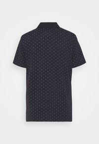 Czarna polo z krótkim rękawem w biały wzór w kropki. Posiada klasyczny kołnierzyk oraz miękką, gładką teksturę materiału.