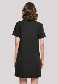 Schwarzes, kurzärmeliges T-Shirt-Kleid aus weicher Baumwolle. Es hat eine lockere Passform und einen geraden Saum, ohne sichtbare Muster oder Logos.