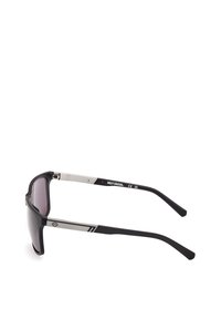 Aurinkolasit mustalla muovikehyksellä, harmailla linsseillä, hopeisilla metallikoristeilla varsissa ja logotiedoilla. Tyylikäs, urheilullinen muotoilu.