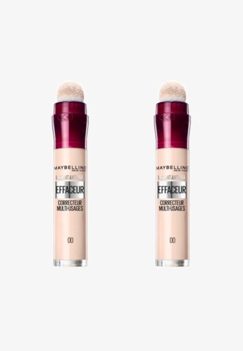 Correcteur anti-âge instantané Maybelline dans un flacon cylindrique. Il dispose d'un applicateur en éponge arrondi. Couleur beige clair avec un capuchon rouge foncé.