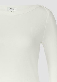 Langärmliges Oberteil in Weiß mit gerippter Struktur, rundem Ausschnitt und dezenten Nahtdetails an den Schultern. Markenlabel sichtbar.