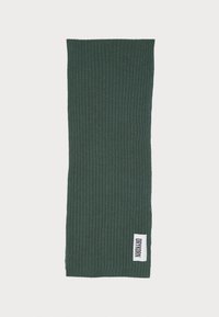 Green ribbed scarf made of textured fabric; features a small label on the side with "DRYKORN" in white text.
