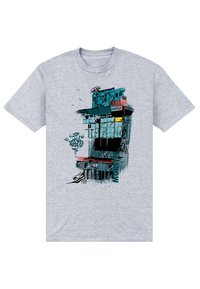 Camiseta gris con un diseño gráfico de un edificio con acentos en azul verdoso y rojo, elementos de graffiti y superposición de texto, impresa en tejido suave.