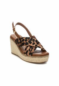 Sandalias de cuña con estampado de leopardo y una correa de cuero marrón, diseño cruzado y suela de yute trenzado. Presentan una plantilla acolchada y cierre con hebilla.