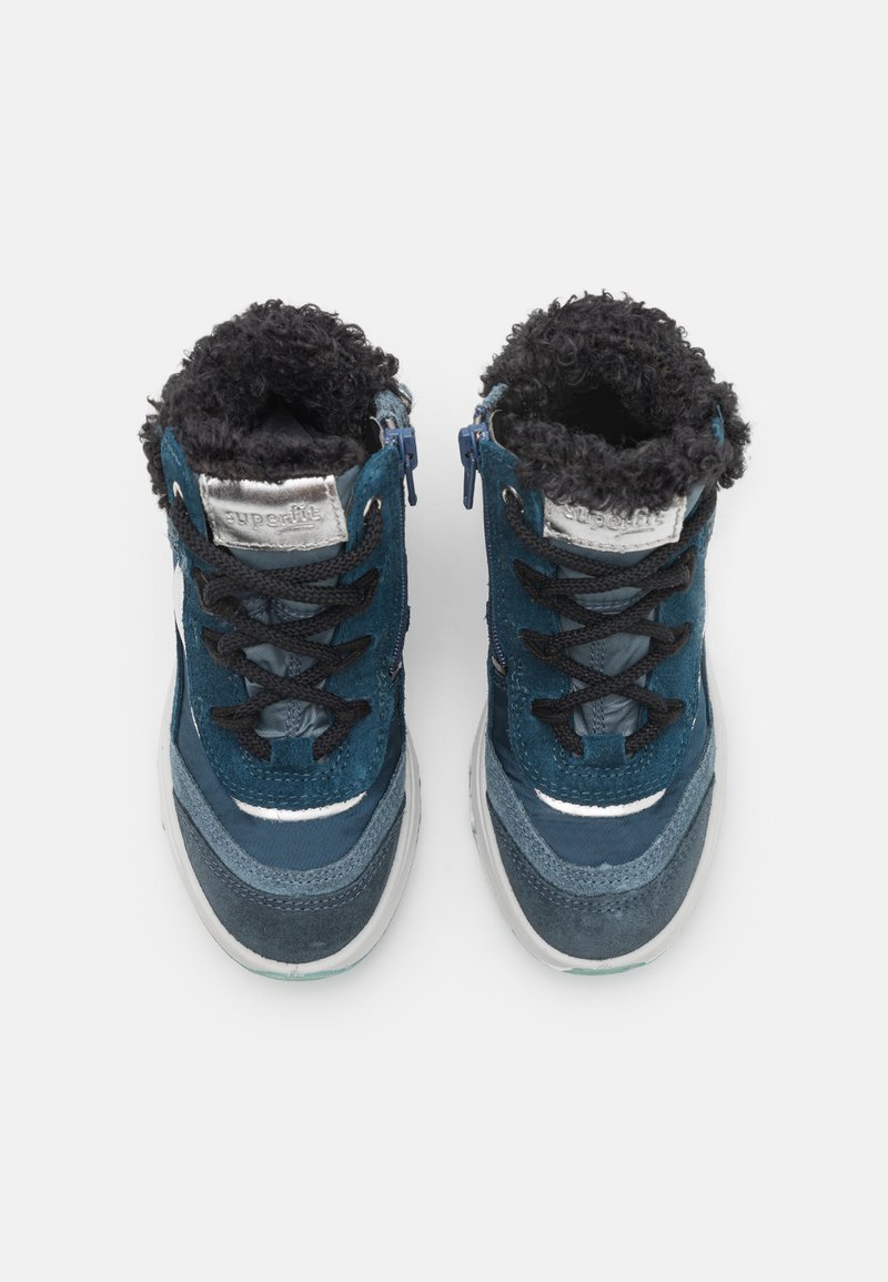 Knöchelhohe, navyblaue Stiefel mit einem strukturierten Fellfutter, schwarzen Schnürsenkeln, seitlichen Reißverschlüssen und einer grauen Gummisohle mit einem geschichteten Design.