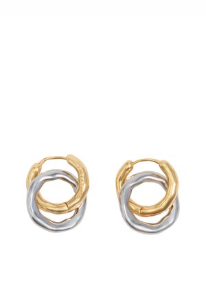 Par de pendientes de aro entrelazados con formas irregulares, uno en tono dorado y otro en tono plateado, exhibidos sobre un fondo blanco.