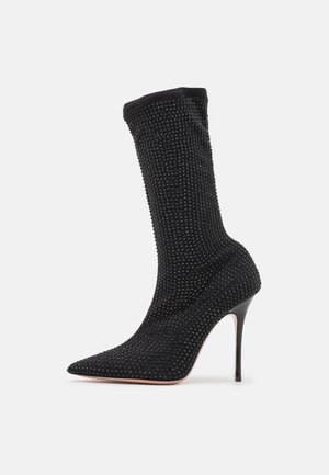 Schwarzer High-Heel-Stiefel mit spitzer Zehenpartie und sockenähnlicher Silhouette. Strukturierter Stoff geschmückt mit kleinen Perlen. Stiletto-Absatzdesign.