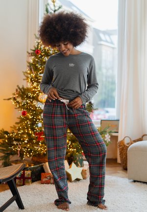 Grijze longsleeve met de tekst "Jolly". Geruite pyjamabroek in blauw, rood en groen. Zachte stof met een elastische tailleband en trekkoord.