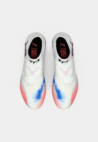 Puma athletic shoes with a white upper, featuring a gradient pattern in red and blue. Textured surface, soft laces, and padded interior.