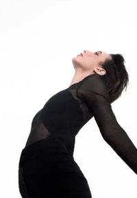 Vestido negro con mangas largas transparentes, silueta fluida, posicionado dinámicamente contra un fondo blanco, enfatizando el movimiento y la forma.