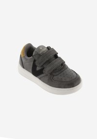 Zapatilla gris con tiras de velcro, materiales de ante y cuero liso, puntera perforada, suela blanca y un logo de acento negro.