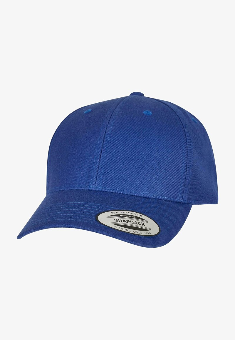 Kék snapback sapka texturált anyagból készült. Hajtott bíborkalappal, hat paneles kialakítással és szellőzőkkel rendelkezik, minimális márkajelzéssel az alsó oldalon.