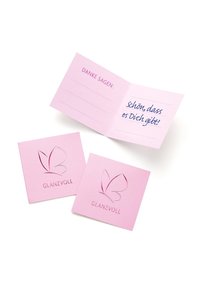 Rožinė raštinė su sulenkta kortele, ant kurios yra ranka rašytas tekstas, ir dviem atitinkamomis kortelėmis, kiekviena su išspaudintu drugelio logotipu ir žodžiu "GLANZVOLL".
