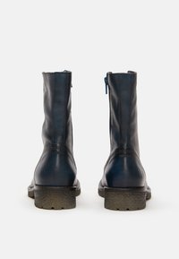 Dunkelblaue Leder-Ankle-Boots mit glatter Oberfläche, Reißverschluss hinten und strukturierten Gummisohlen. Einfaches Design mit minimalen Nähten.