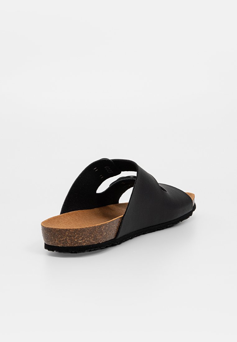 Schwarze Leder-Sandale mit Korkfußbett, offenes Fersen-Design und gebogener Sohle. Verfügt über zwei breite Riemen, die sich oben überkreuzen.