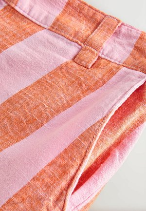 Stribet stof med skiftevis kraftig orange og lys pink farver, med en tekstureret overflade og synlig syningsdetalje på taljebåndet.