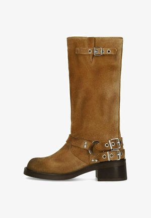 Botte en daim marron mi-mollet avec deux sangles à boucles argentées à la cheville et une près du haut, bout rond et talon carré bas.