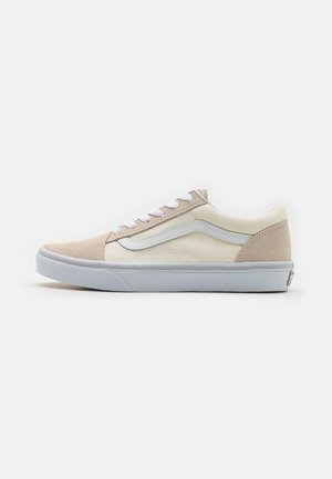 Zapatillas de ante y lona beige con acentos blancos, cierre de cordones y suela de goma. Detalle de franja lateral, diseño minimalista.