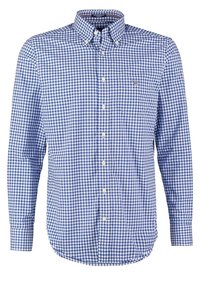 Chemise à manches longues à carreaux bleus et blancs, à boutons, avec col boutonné et petit logo sur la poitrine.