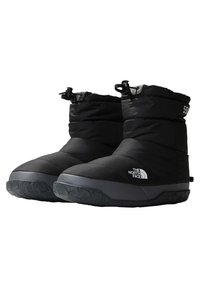 Botas aislantes negras con una parte superior texturizada, diseño acolchado, suelas de goma y un logo en el lateral, con cierres de cordón en la parte superior.