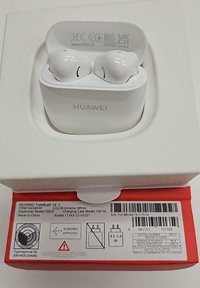 Weiße kabellose Ohrhörer in einem runden Ladeetui. Das Etui hat eine glatte Oberfläche und bedruckte Produktinformationen auf der Rückseite.