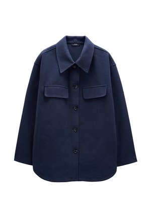 Granatowa flanelowa kurtka koszulowa z zapięciem na guziki, dużym kołnierzem, dwiema kieszeniami na piersi i luźnym krojem. Miękka tekstura. Zaokrąglony dół.