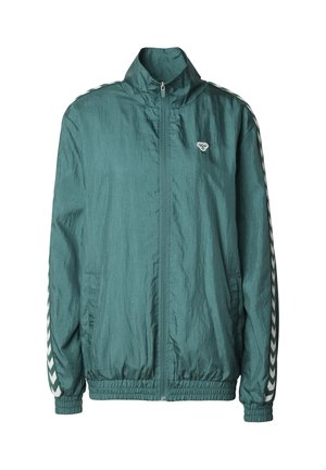 Veste coupe-vent zippée bleu sarcelle avec poignets et ourlet élastiques, rayures chevrons blanches sur les manches, et petit logo sur la poitrine gauche.