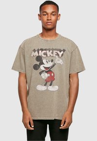 Ruda per didelį dydį marškinėlius su vintage Mickey Mouse grafika juoda, raudona ir balta spalvomis. Apvalus iškirpimas ir trumpomis rankovėmis.