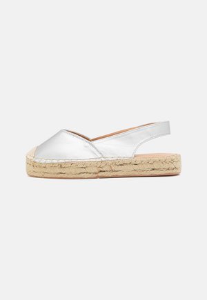 Espadrille plateado metálico sin cordones con suela de yute trenzado, que presenta un diseño de talón abierto y un material superior suave.
