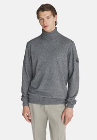 Maglione grigio a collo alto lavorato a maglia con polsini e orlo a costine. Presenta una piccola etichetta logo sulla manica sinistra. Texture liscia.