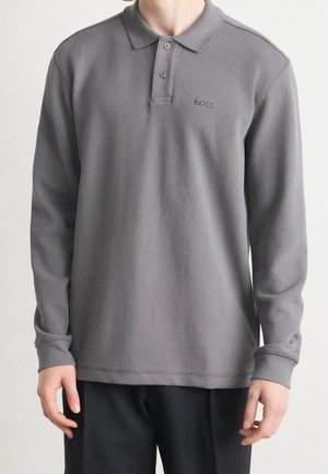 Polo à manches longues gris en tissu texturé, avec patte de boutonnage à deux boutons et logo brodé. Comprend un col standard et des poignets côtelés.