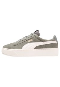 Sneakers in suede grigio con suola in gomma bianca a piattaforma, dotati di una linguetta in rete testurizzata, lacci piatti e un accento di logo dorato sul lato.