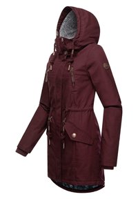 Veste à capuche bordeaux avec doublure en polaire, taille réglable par cordon, deux poches zippées à l'avant et manches ajustables, avec un dos plus long.