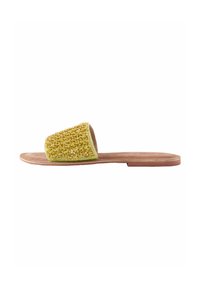 Sandalia tipo slide con parte superior de tejido amarillo texturizado, suela plana marrón y diseño de punta abierta. Presenta una plantilla suave y un estilo minimalista.