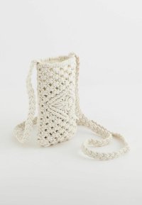 Cotton macramé bag in cream color, cylindrical shape with a braided strap. Features intricate woven pattern for texture and design detail.
